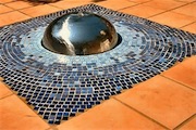 Stainless steel and tile water feature, set within a terracotta tile terrace.